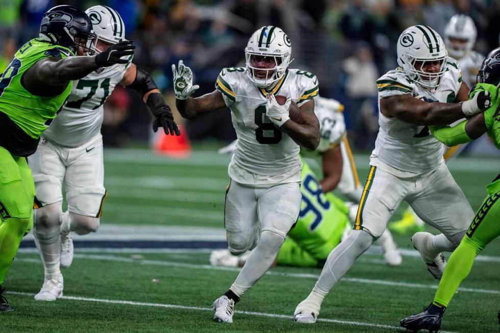 Green Bay Packers running back Josh Jacobs runs with the ball during an NFL football game again ...