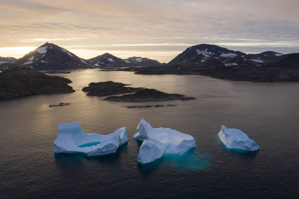 Large Icebergs float away as the sun rises near Kulusuk, Greenland, Aug. 16, 2019. (AP Photo/Fe ...