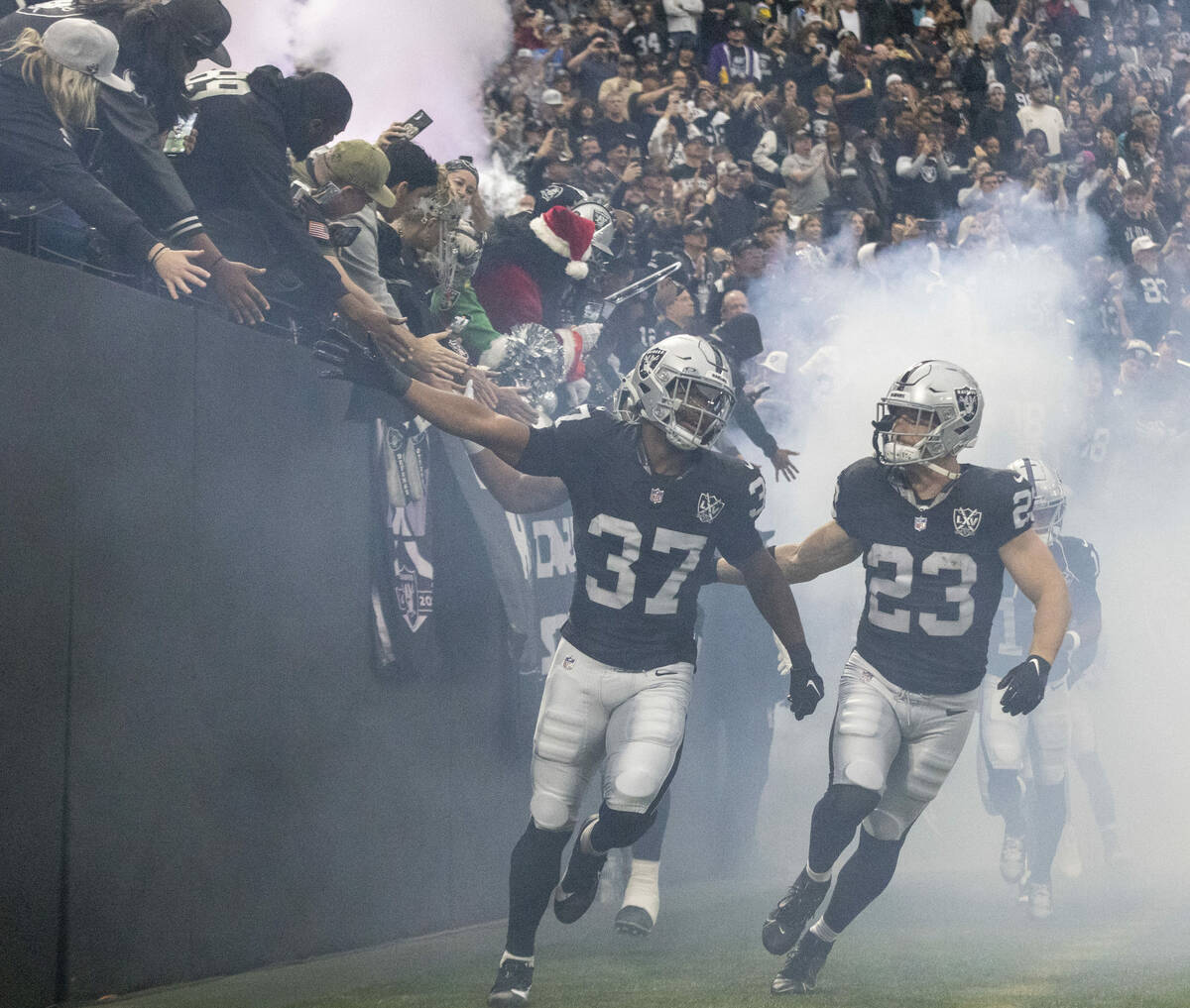 Raiders safety Trey Taylor (37) and running back Dylan Laube (23) take the field as the team is ...