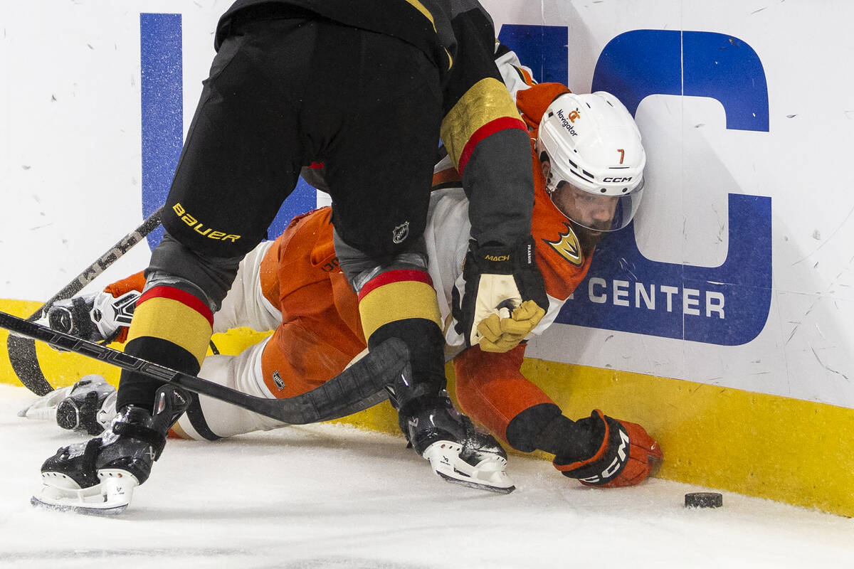 Anaheim Ducks defenseman Radko Gudas (7) watches the puck while being pushed up against the boa ...