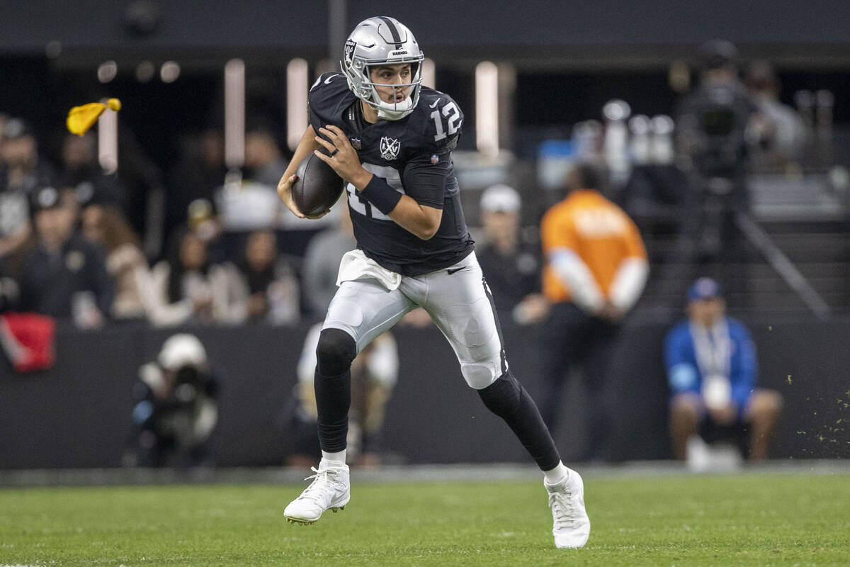 Raiders quarterback Aidan O'Connell (12) scrambles on a play during the first half of an NFL ga ...