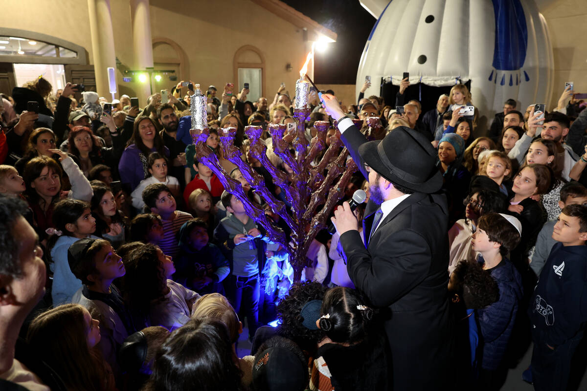 Rabbi Yossi Shuchat lights the menorah on the first night of Hanukkah at Or Bamidbar Chabad in ...