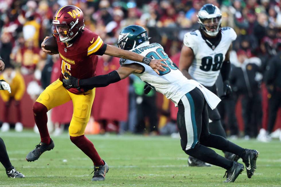 Washington Commanders quarterback Jayden Daniels (5) runs with the ball during an NFL football ...