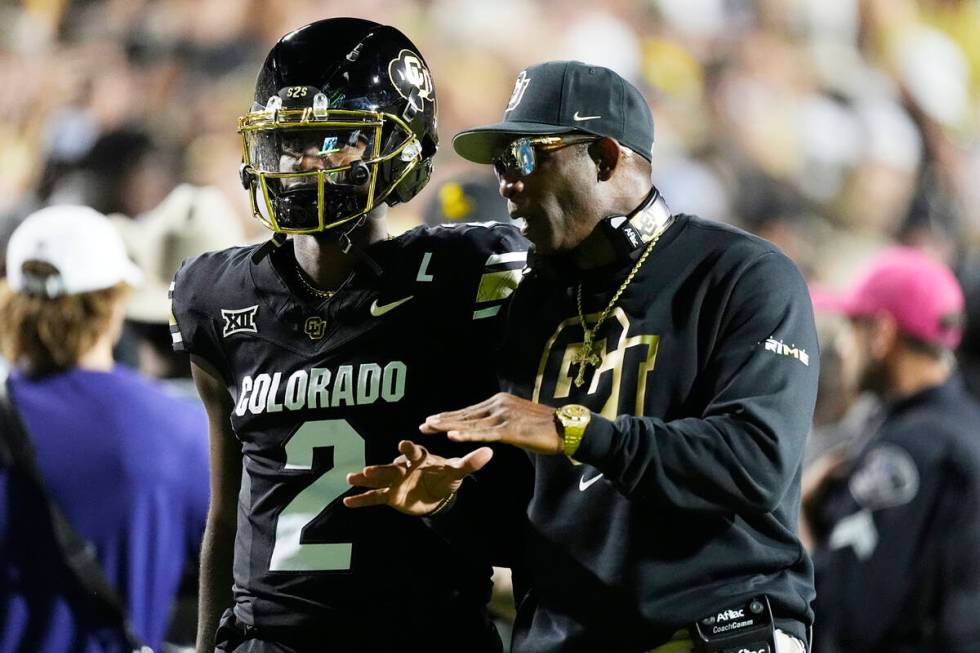 Colorado head coach Deion Sanders confers with his son, quarterback Shedeur Sanders, in the fir ...