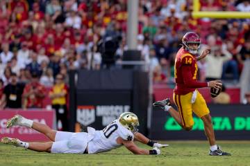 Southern California quarterback Jayden Maiava, right, runs past Notre Dame defensive lineman Lo ...