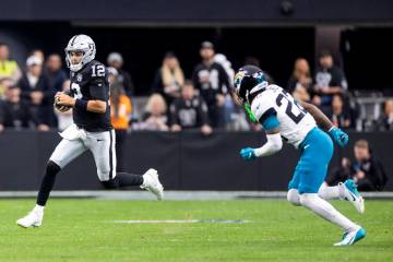 Raiders quarterback Aidan O'Connell (12) runs with the ball during the first half of the NFL ga ...