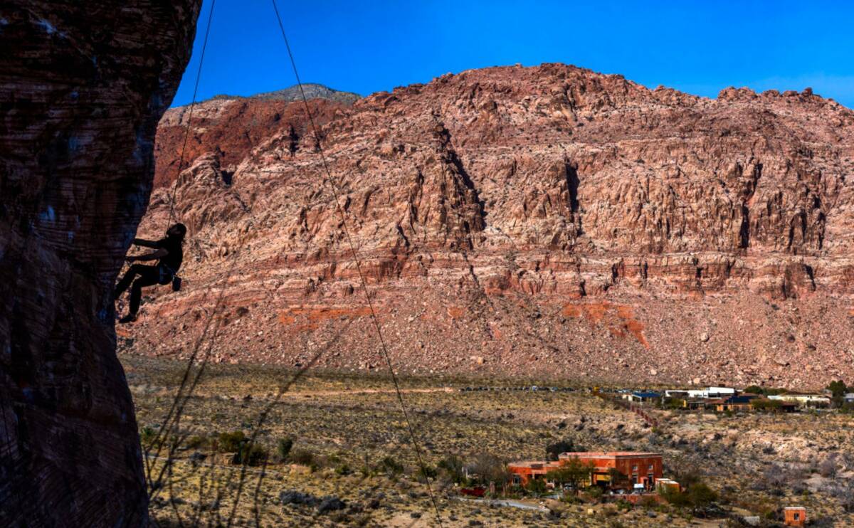 A rock climber looks up with on a giant boulder in Calico Basin on Thursday, Dec. 26, 2024, in ...