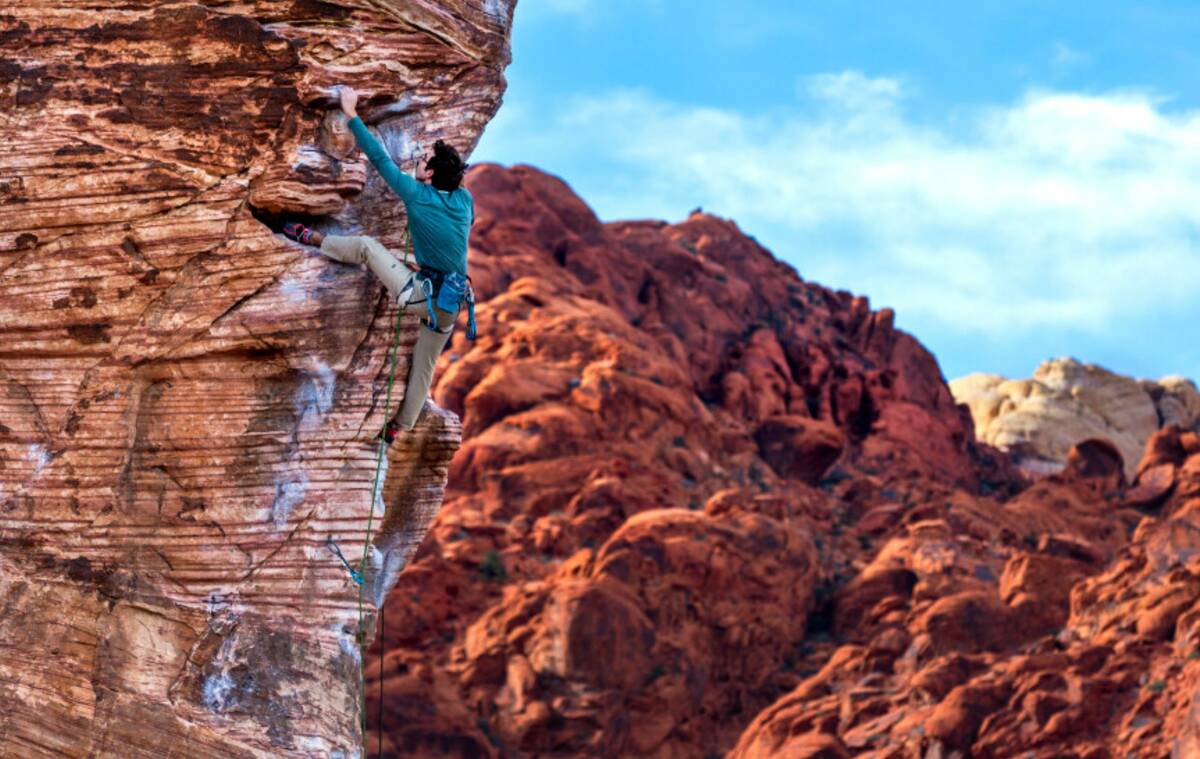 Jack Nelson of Orlando works his way up the "caustic" route on a large boulder in Calico Basin ...