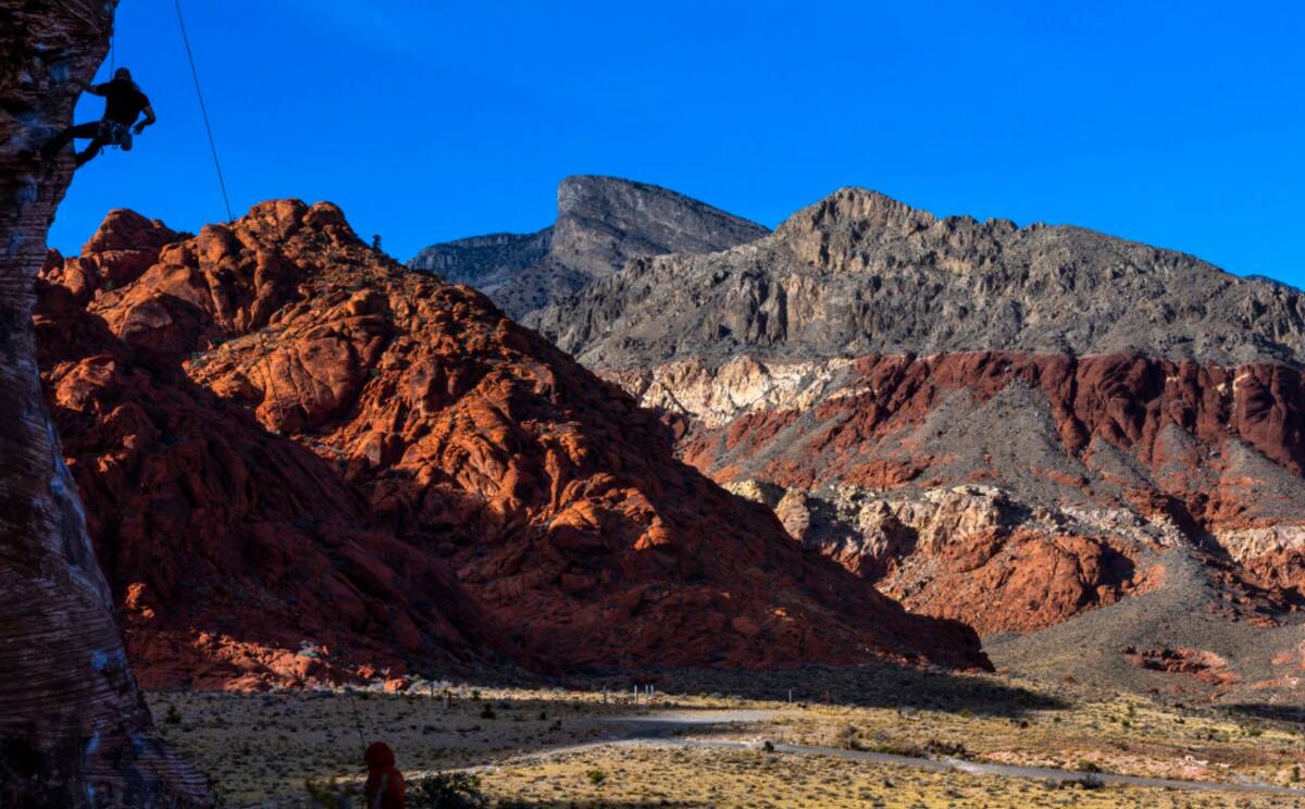 A rock climber looks up with on a giant boulder in Calico Basin on Thursday, Dec. 26, 2024, in ...