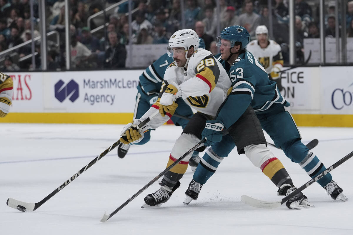 Vegas Golden Knights center Tanner Laczynski (28) moves the puck while being defended by San Jo ...