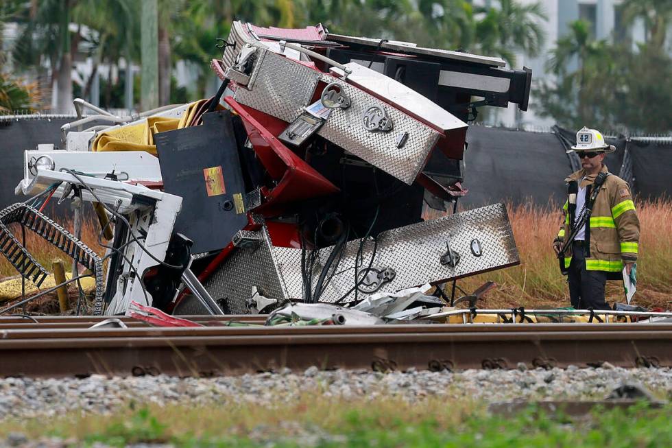 A fireman views damage after a Brightline train collided with a fire truck in downtown Delray B ...