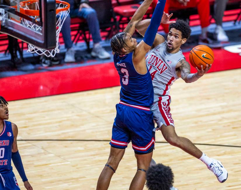 UNLV guard Jailen Bedford (14) looks to shoot around Fresno State Bulldogs forward Elijah Price ...