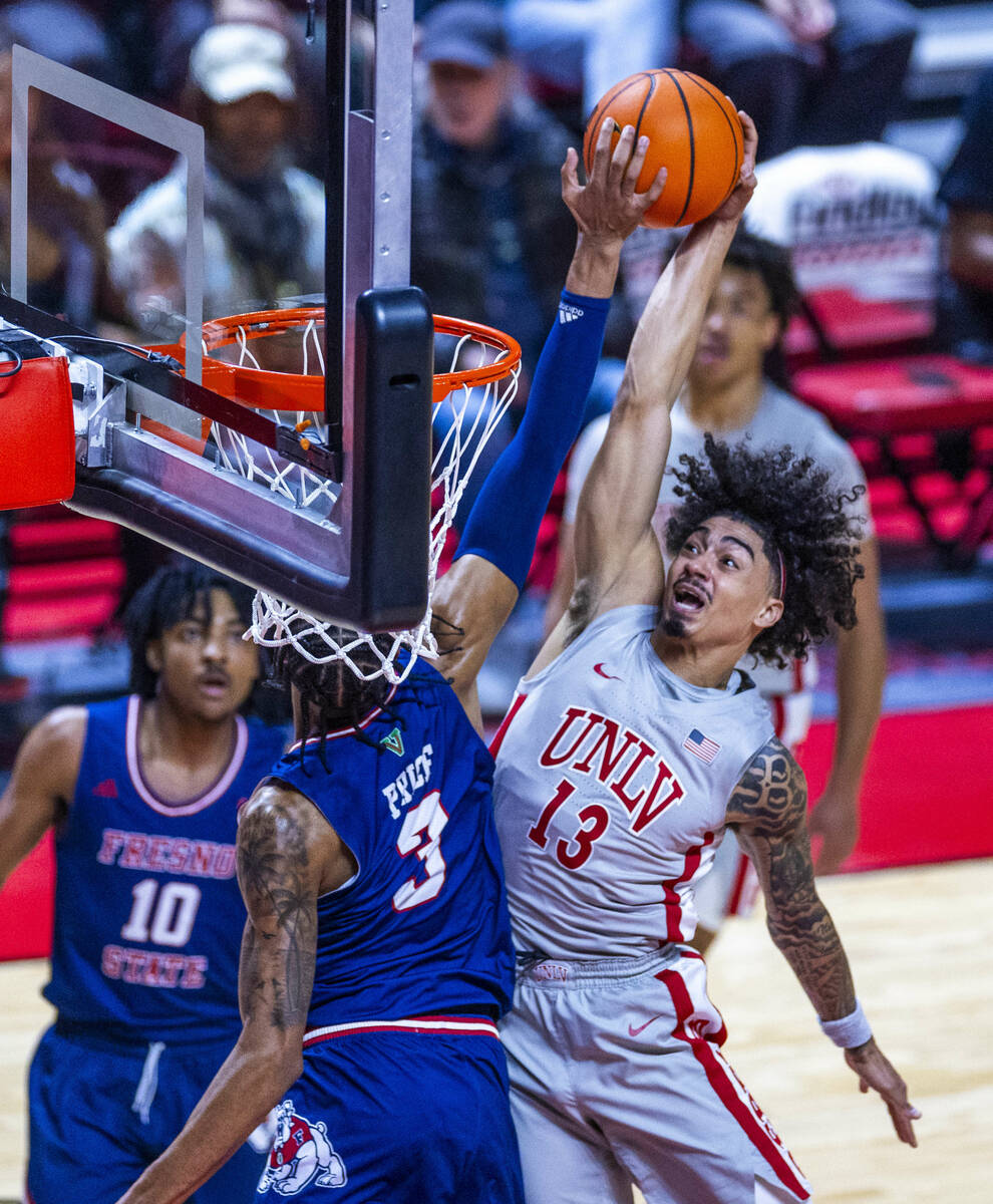 UNLV guard Brooklyn Hicks (13) attempts to shoot but is blocked by Fresno State Bulldogs forwar ...