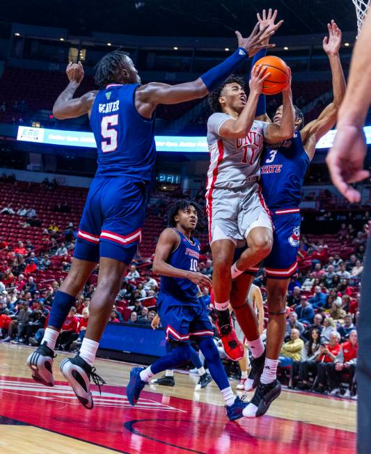 UNLV guard Dedan Thomas Jr. (11) battles inside for a shot against Fresno State Bulldogs guard ...