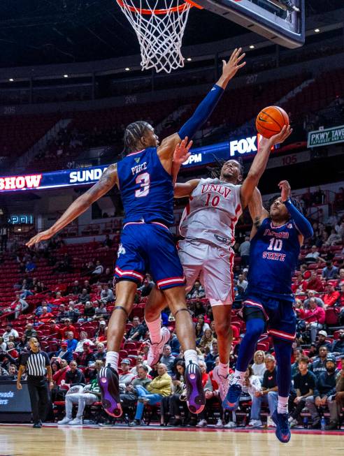 UNLV guard Jaden Henley (10) battles for a shot between Fresno State Bulldogs forward Elijah Pr ...