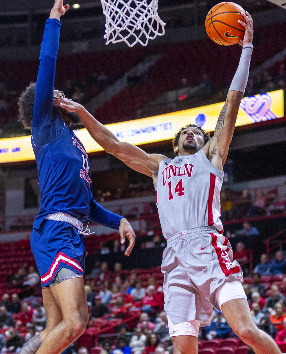 UNLV guard Jailen Bedford (14) battles to shoot against Fresno State Bulldogs forward Mykell Ro ...