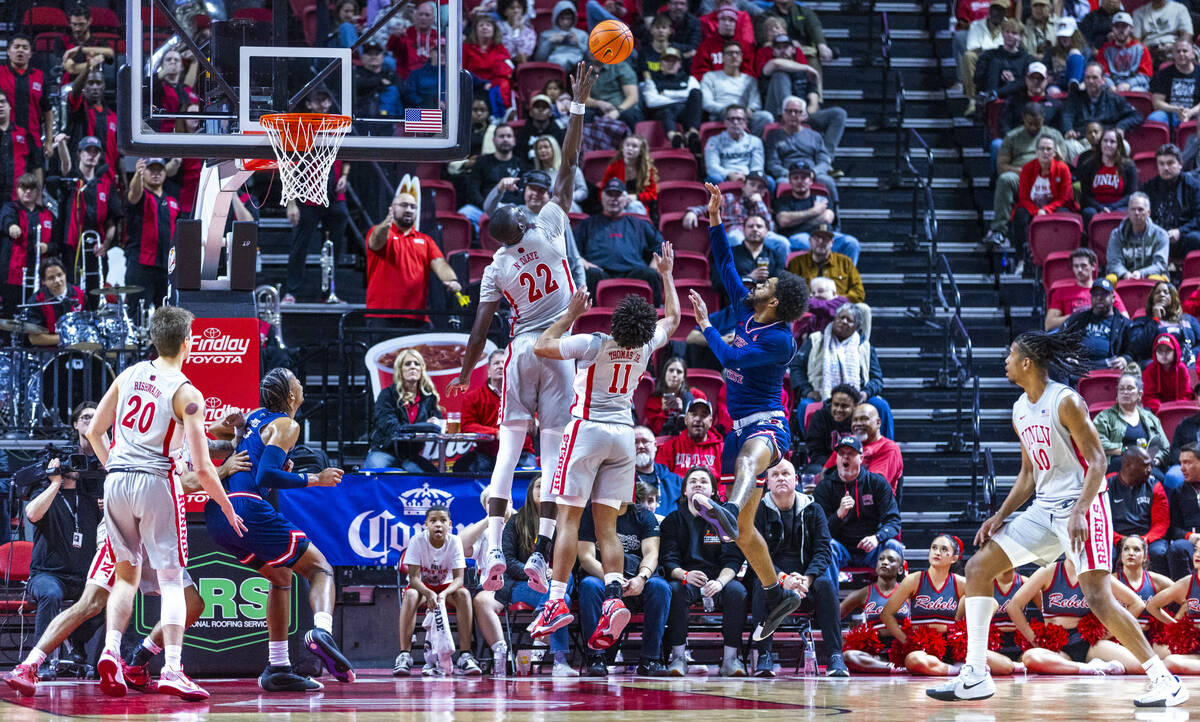 UNLV forward Pape N'Diaye (22) gets up above the rim to reject a shot by Fresno State Bulldogs ...