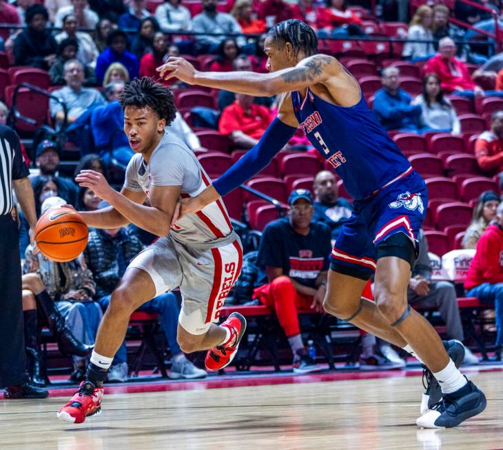 UNLV guard Dedan Thomas Jr. (11) drives the lane against Fresno State Bulldogs forward Elijah P ...