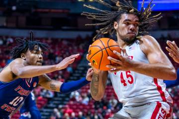 UNLV forward Jeremiah Cherry (45) looks for a shot against Fresno State Bulldogs guard Zaon Col ...