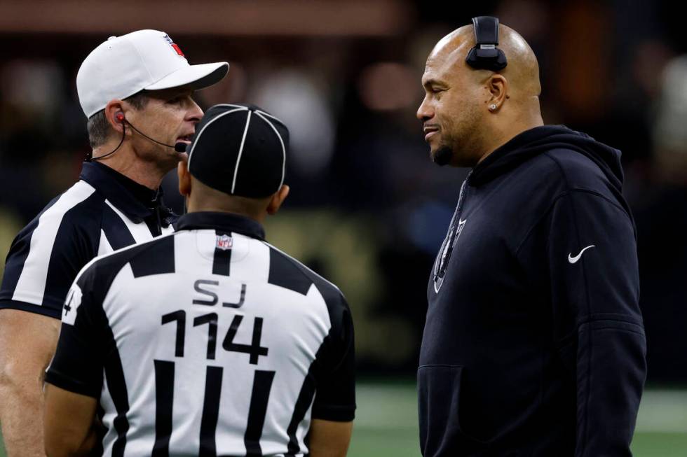 Las Vegas Raiders head coach Antonio Pierce, right, talks with officials during the first half ...