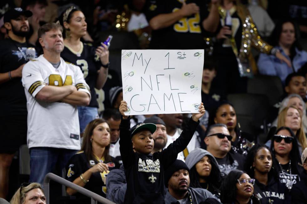 A fan holds a sign during the first half of an NFL football game between the New Orleans Saints ...