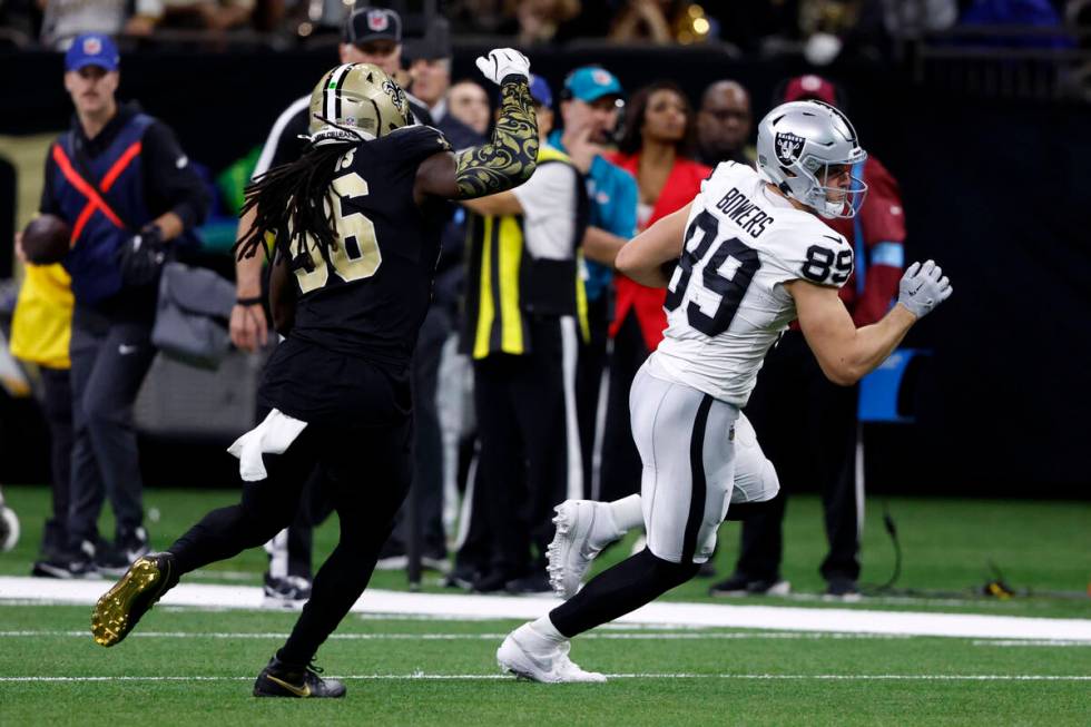 Las Vegas Raiders tight end Brock Bowers (89) runs from New Orleans Saints linebacker Demario D ...