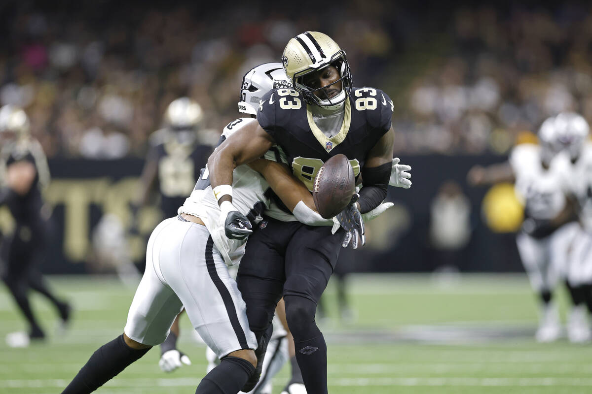 New Orleans Saints tight end Juwan Johnson (83) has the ball knocked out by Las Vegas Raiders s ...