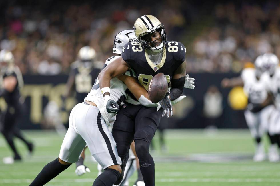 New Orleans Saints tight end Juwan Johnson (83) has the ball knocked out by Las Vegas Raiders s ...