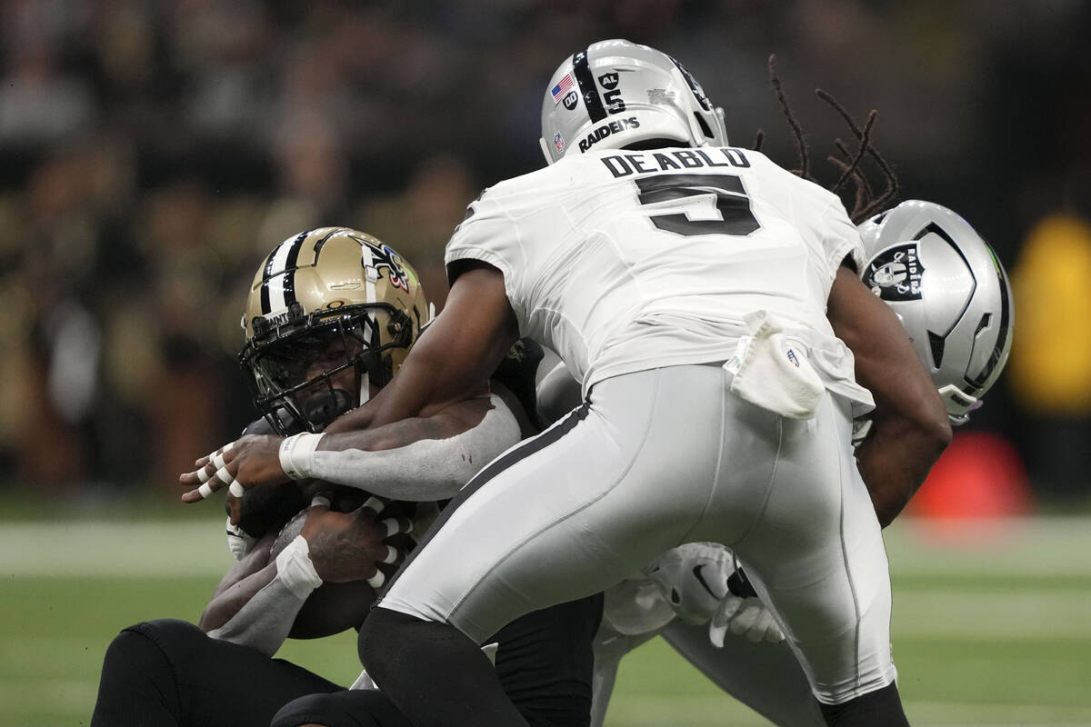 New Orleans Saints running back Jamaal Williams is tackled by Las Vegas Raiders linebacker Divi ...