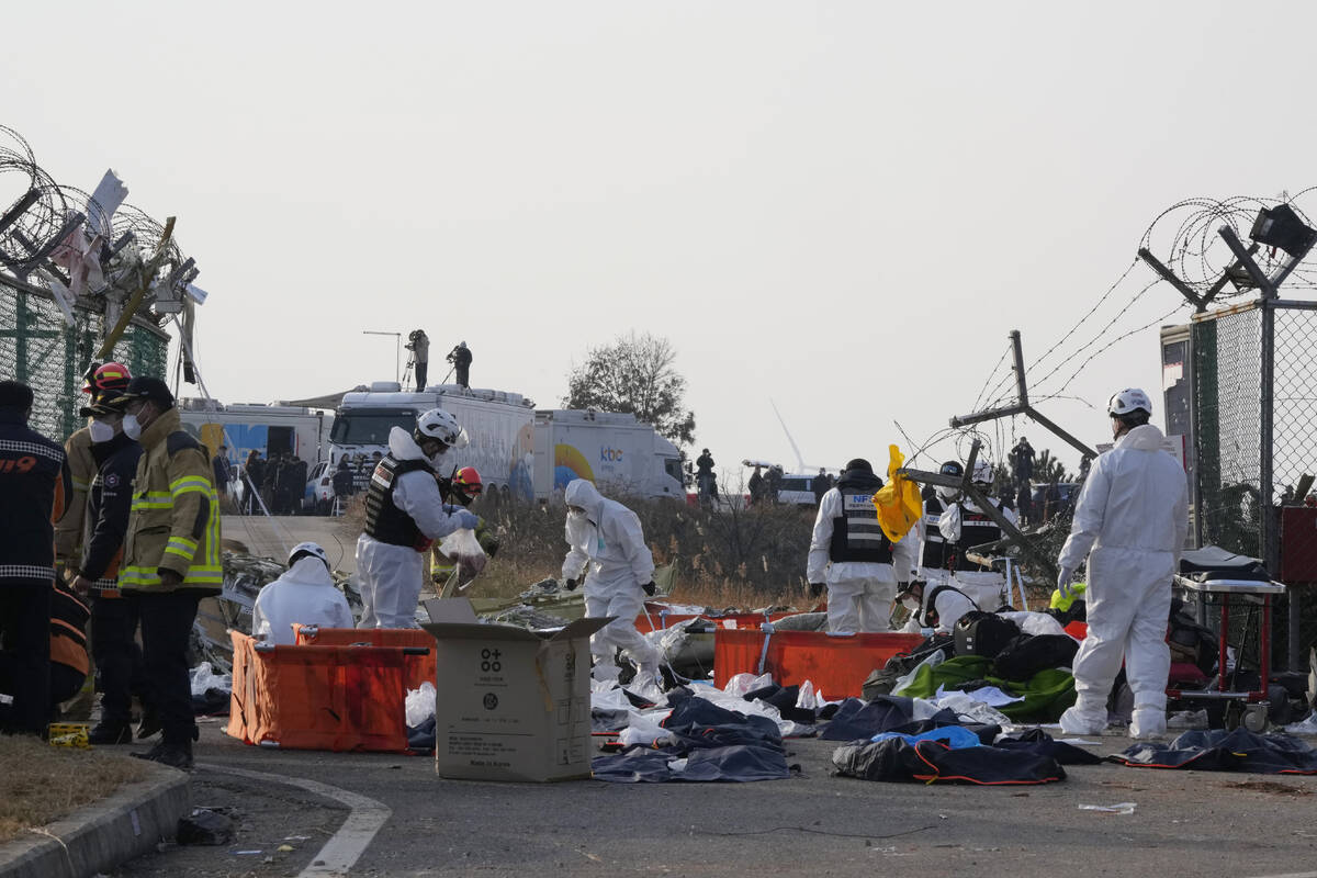 Rescue team members work outside of Muan International Airport in Muan, South Korea, Sunday, De ...