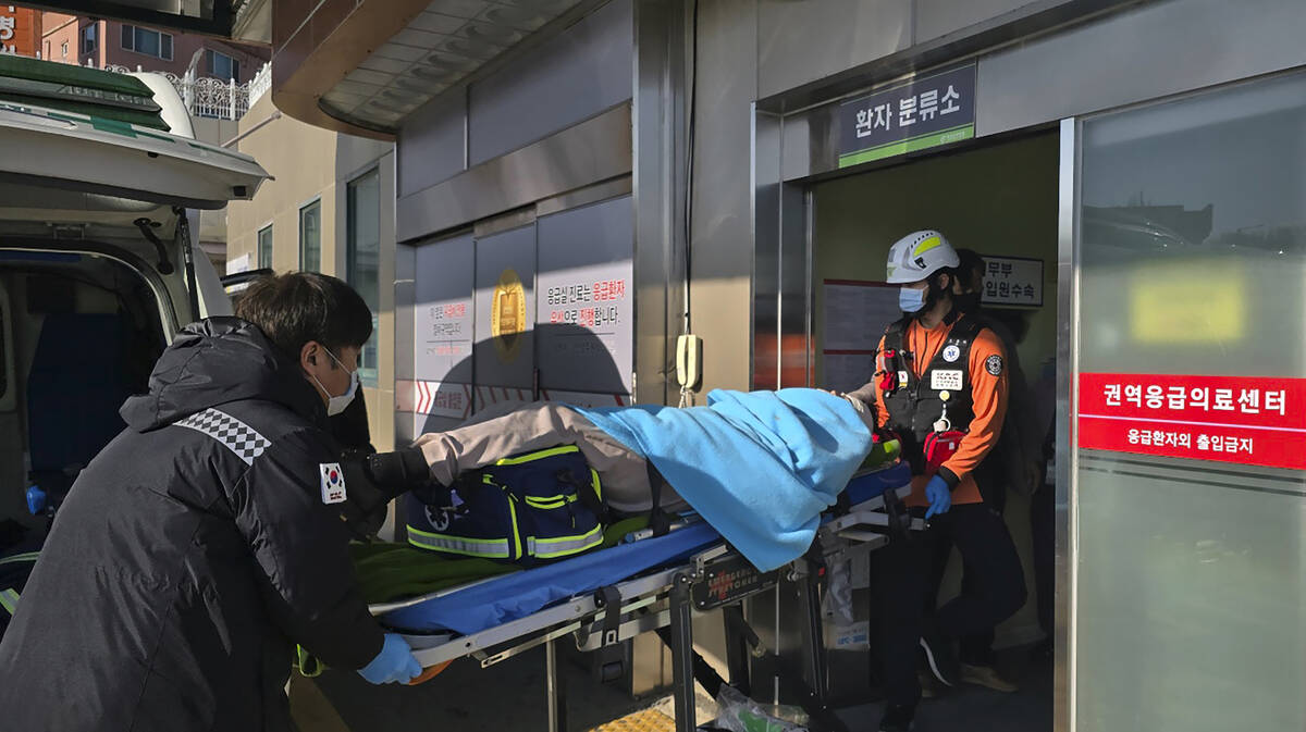 A victim rescued from a plane crash is transported to a hospital in Mokpo, South Korea, Sunday, ...