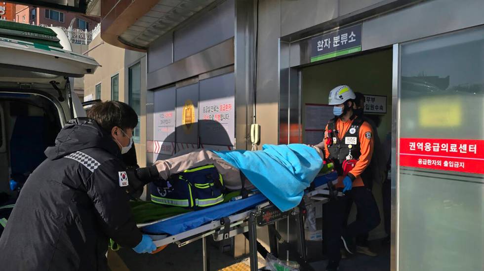 A victim rescued from a plane crash is transported to a hospital in Mokpo, South Korea, Sunday, ...