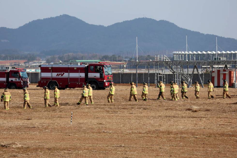 Firefighters and rescue team members work at Muan International Airport in Muan, South Korea, S ...