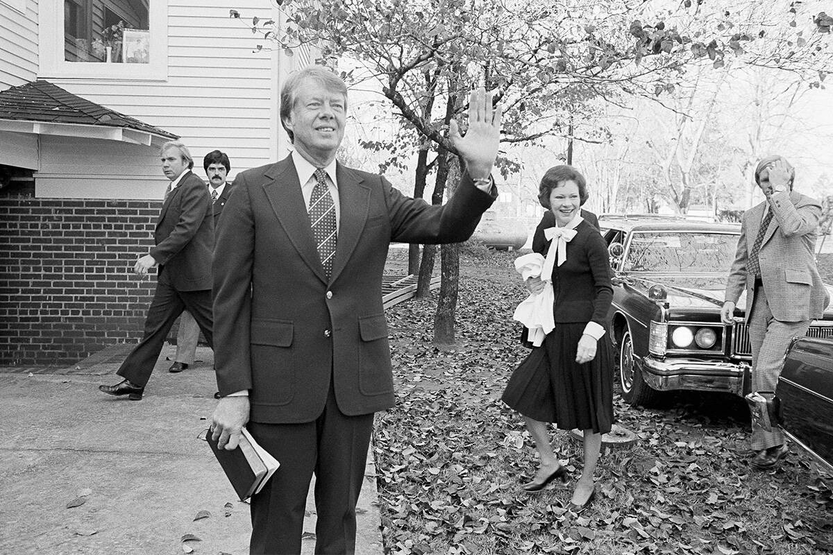 FILE - President-elect Jimmy Carter waves to the crowd as he and his wife Rosalynn arrive at th ...