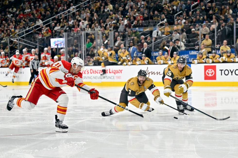 Calgary Flames center Mikael Backlund (11) takes a shot against Vegas Golden Knights defenseman ...