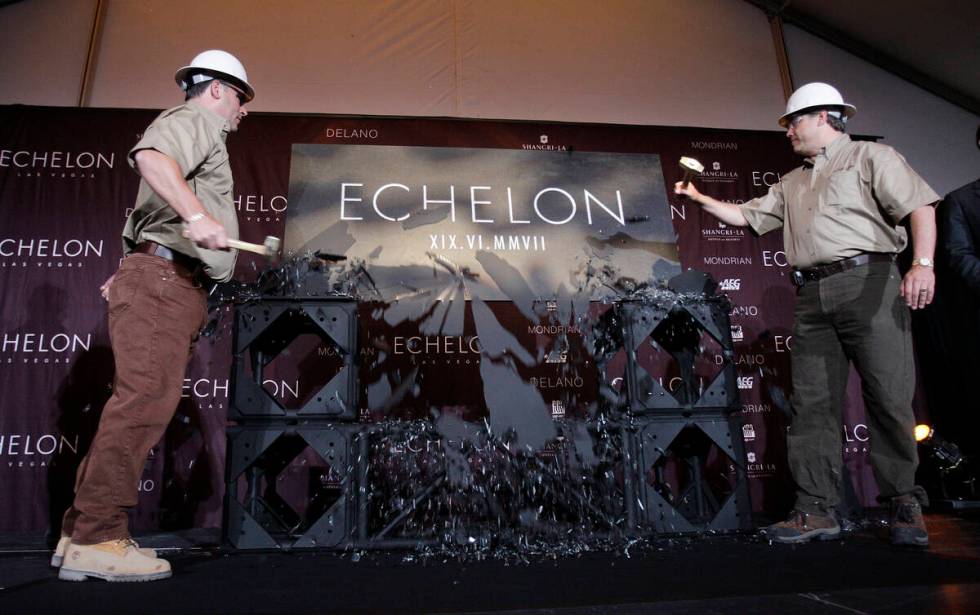 Echelon executives Bob Marra, left, and Ron Frye, use hammers to break a sheet of glass to reve ...