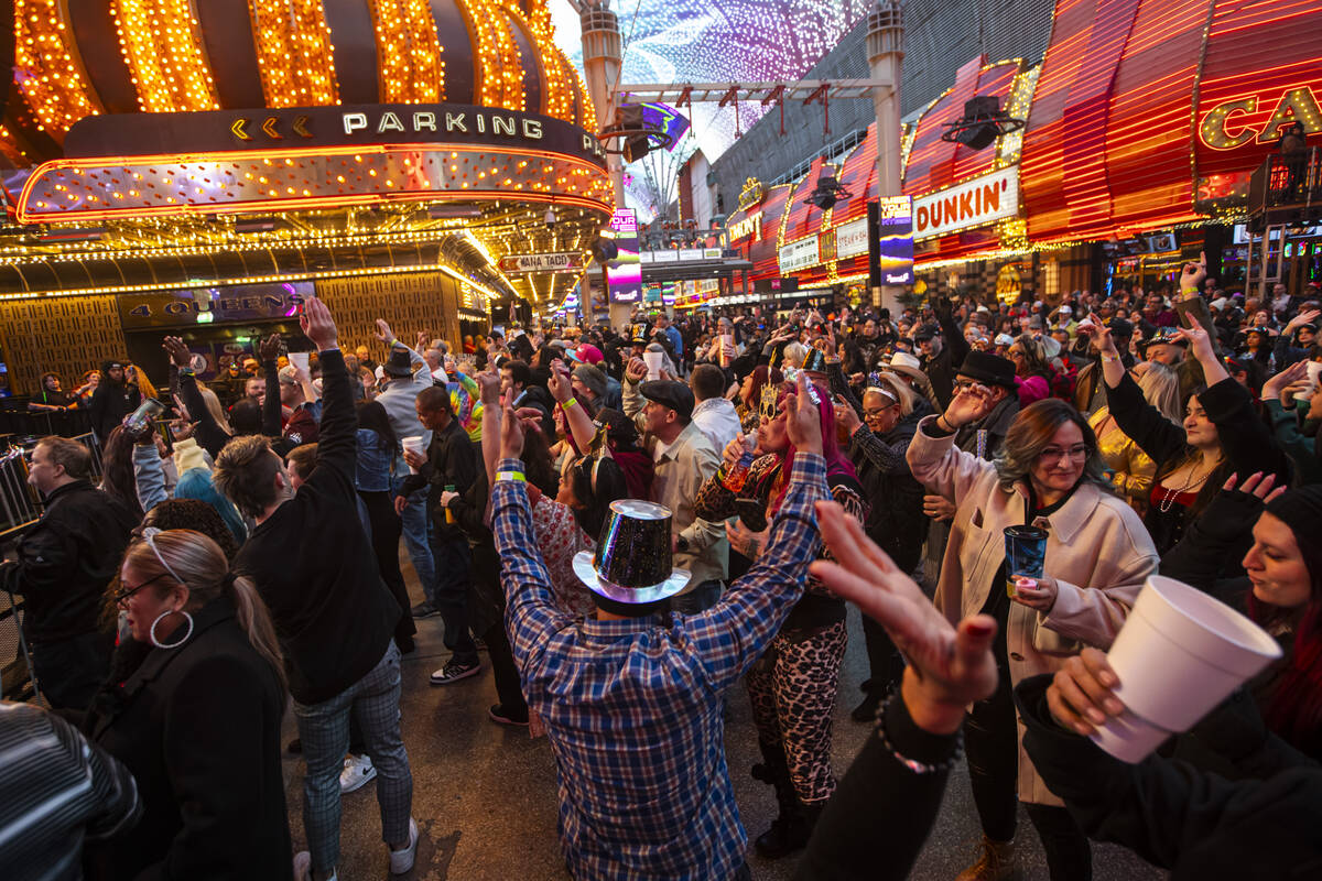 People dance to music during the New Year’s Eve celebration at the Fremont Street Experi ...