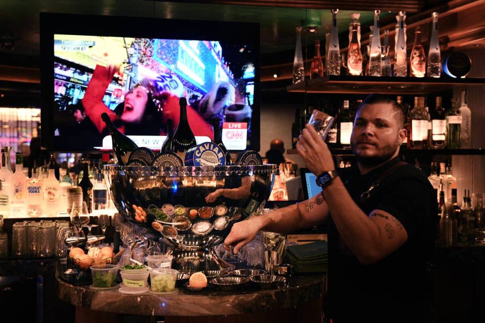 A bartender checks a glass in front of a caviar display at Caspian’s at Caesars Palace T ...