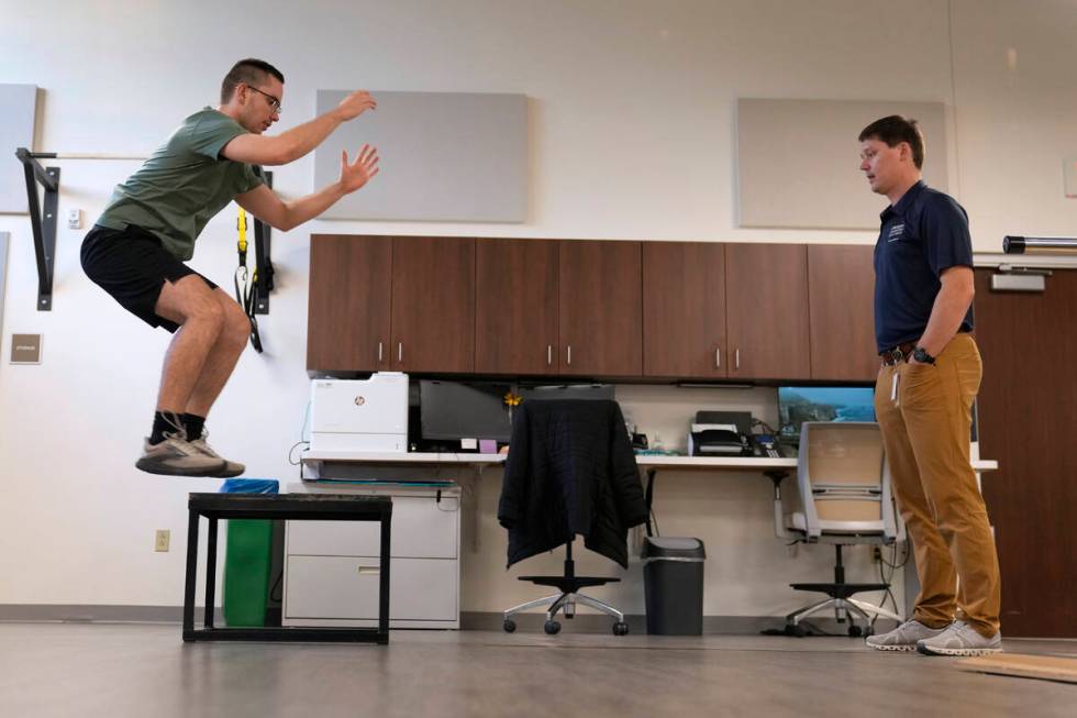 Physical therapist Tyler Detmer, right, works with patient Jacob Bullard at WashU, Monday, Dec. ...