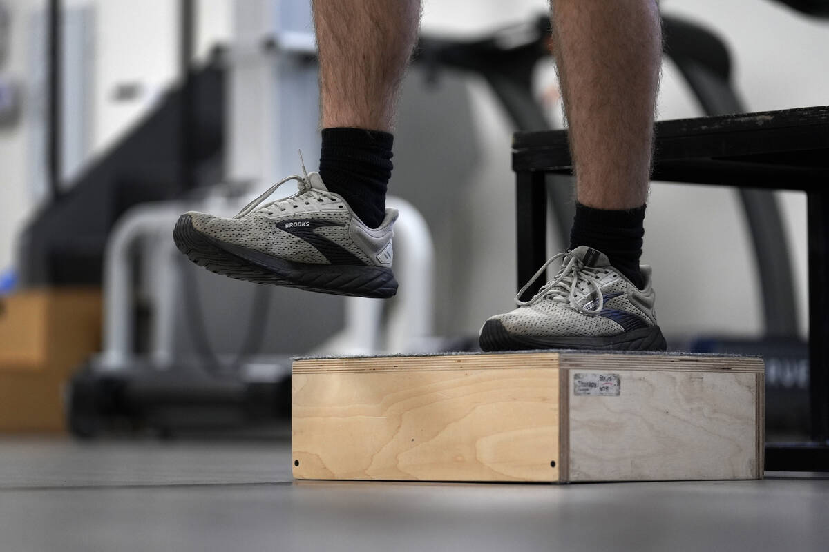 Jacob Bullard steps off a box as part of his physical therapy at WashU, Monday, Dec. 16, 2024, ...