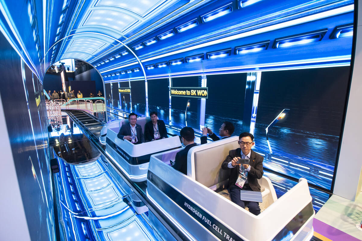 Attendees ride on a hydrogen fuel cell train at the SK Group booth during the first day of CES ...