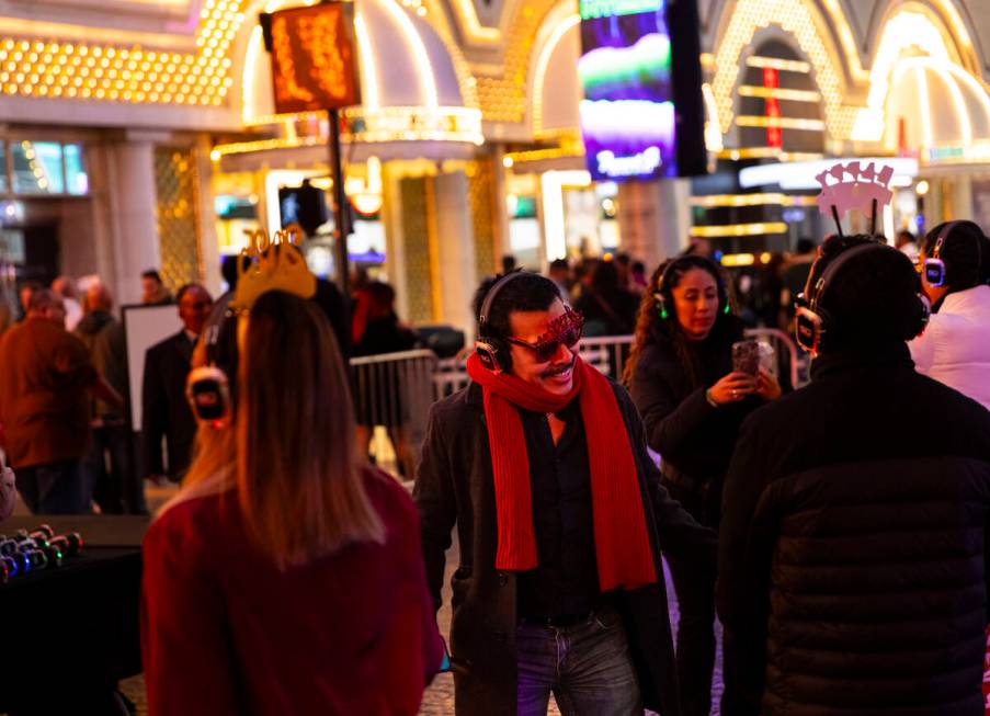 People dance to a silent disco party during the New Year's Eve celebration at the Fremont Stree ...