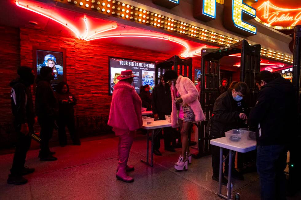 New Year's Eve revelers make their way through security at the Fremont Street Experience Tuesda ...