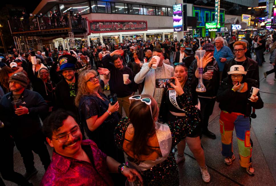 People pose for photos during the New Year’s Eve celebration at the Fremont Street Exper ...