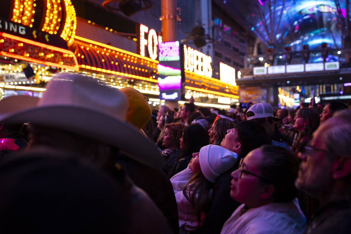 New Year's Eve revelers look up at the Fremont Street Experience Viva Vision display Tuesday, D ...