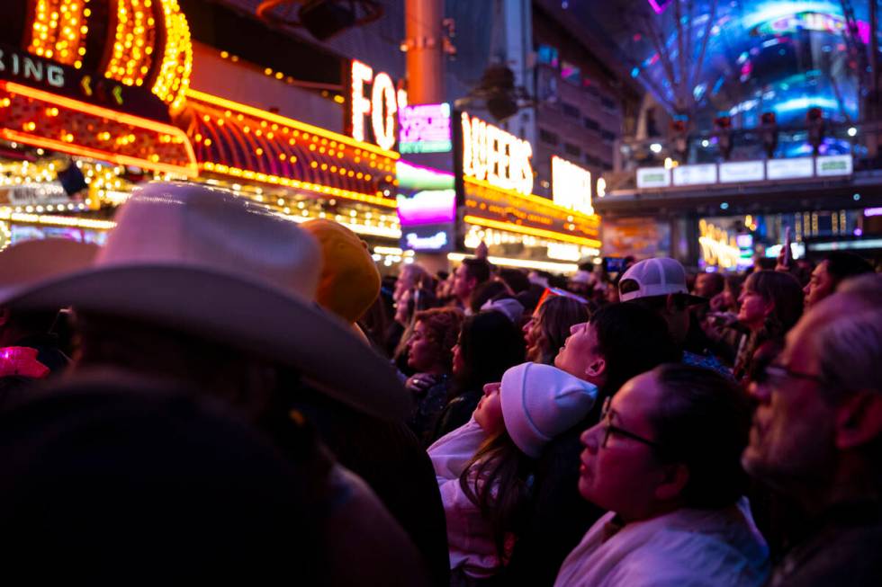 New Year's Eve revelers look up at the Fremont Street Experience Viva Vision display Tuesday, D ...