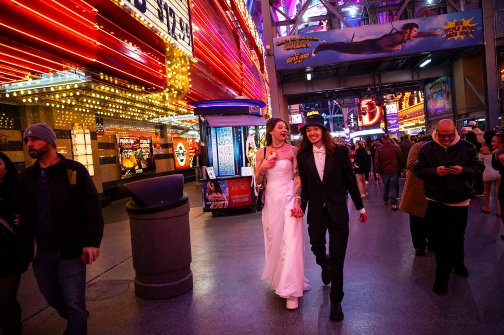 Newlyweds Lexi and Drew Eslinger, of Las Vegas, walk the Fremont Street Experience during the N ...