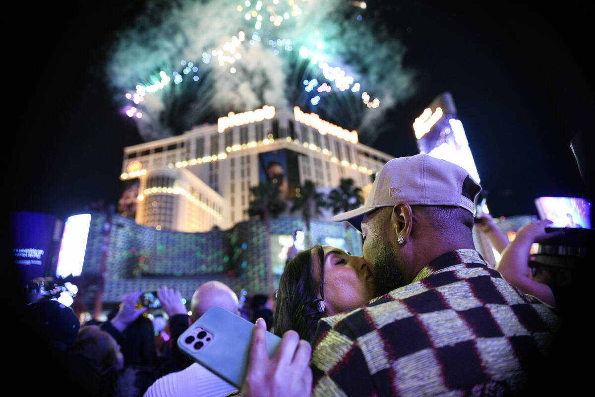 Leslie Ruiz and Chuck, no last name given, kiss as they ring in the new year on the Strip Wedne ...