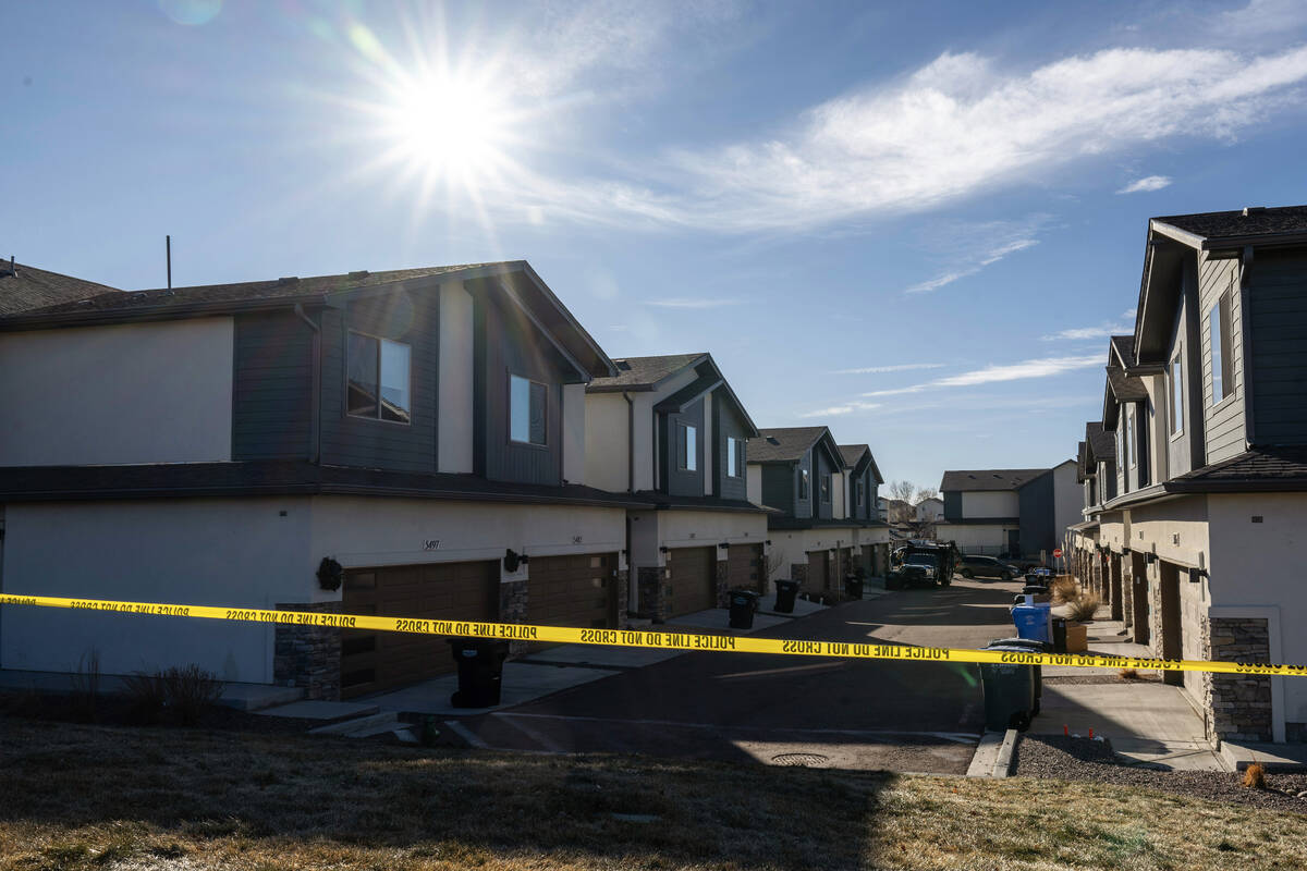 Police tape blocks off a section of townhomes as investigators search a home in northeastern Co ...