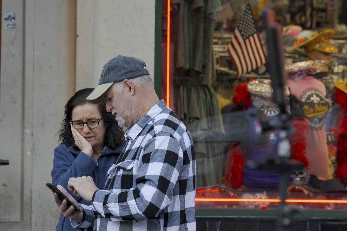 People react at the intersection of Bourbon Street and Canal Street during the investigation af ...